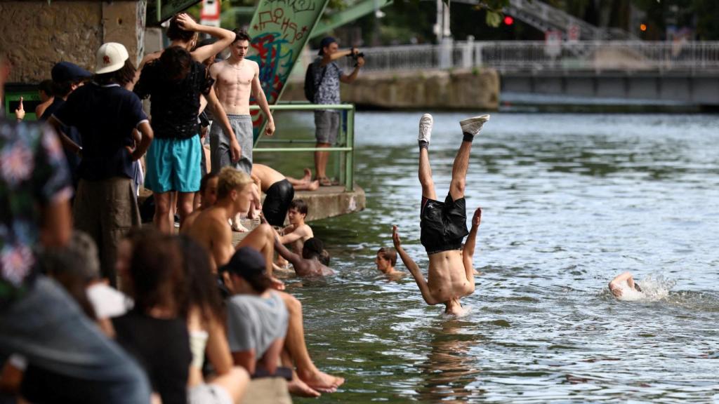 Un grupo de jóvenes salta al canal de Saint-Martin en un día de verano soleado y caluroso en París, mientras que una ola de calor temprana Francia, el 2 de julio de 2025.