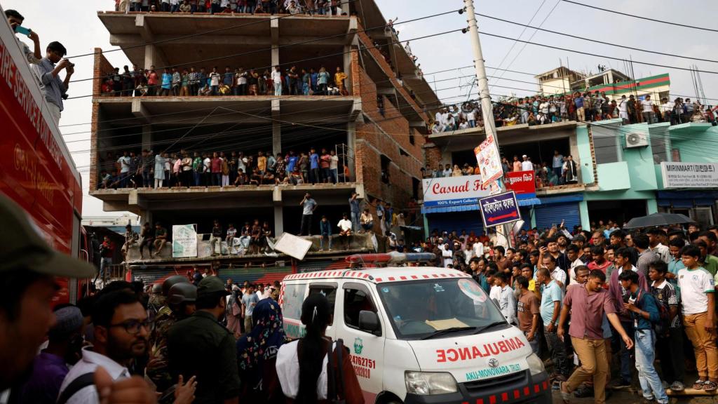 Una ambulancia intenta salvar a algunos de los heridos en el accidente del avión de Bangladés