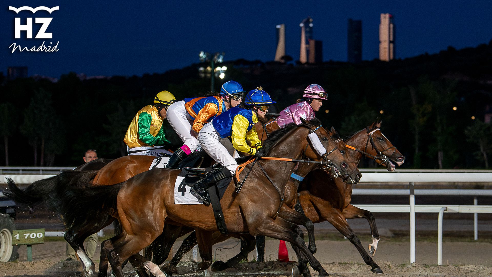 Peloton con las cuatro vueltas de Madrid en el fondo, hipódromo de la raza de caballos de la Zarzuela