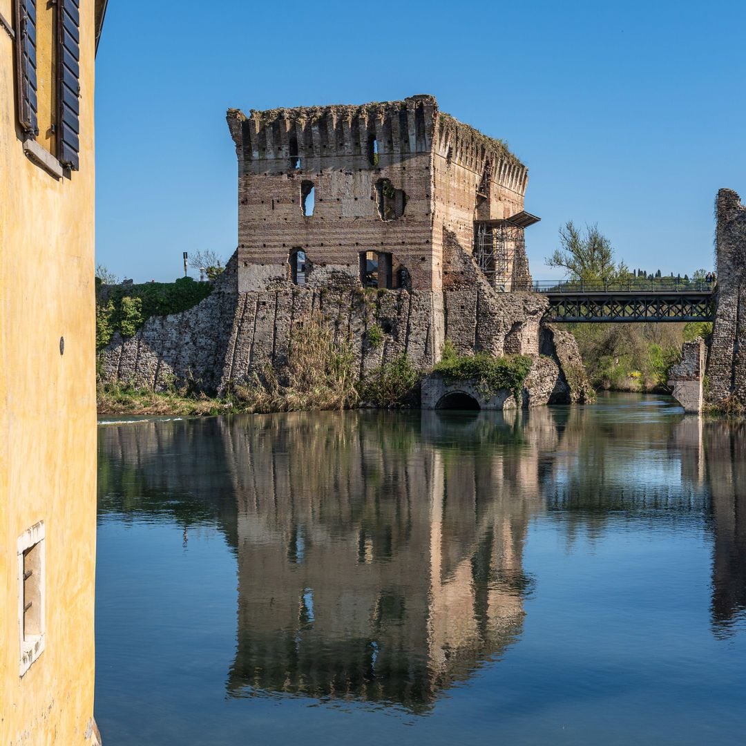 Ruinas del puente Visconti que se refleja en el agua de Borghetto Sulcio, un pueblo de Valeggio Sulcio, en la región de Véneto, Italia en Italia