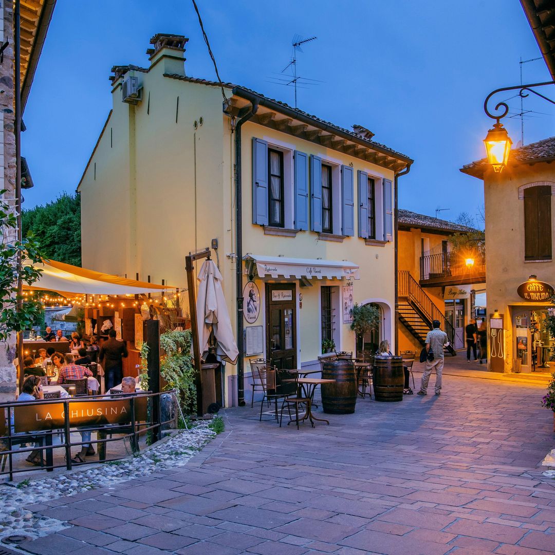Callejón con restaurantes en la histórica ciudad de Borghetto en el anochecer, distrito de Valeggio Sulcio, Italia