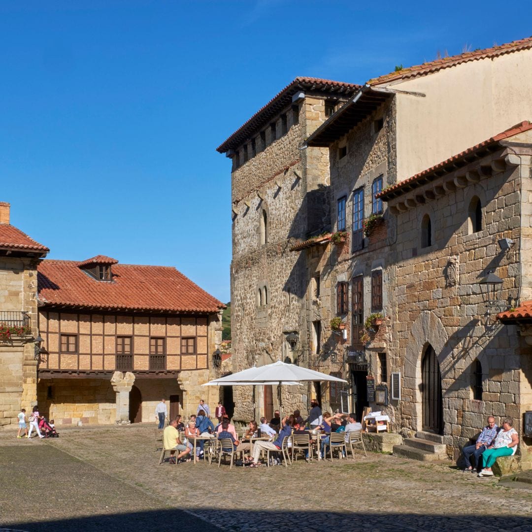 Plaza con la gente del fresco de la ciudad cantabriana de Santillana del Mar