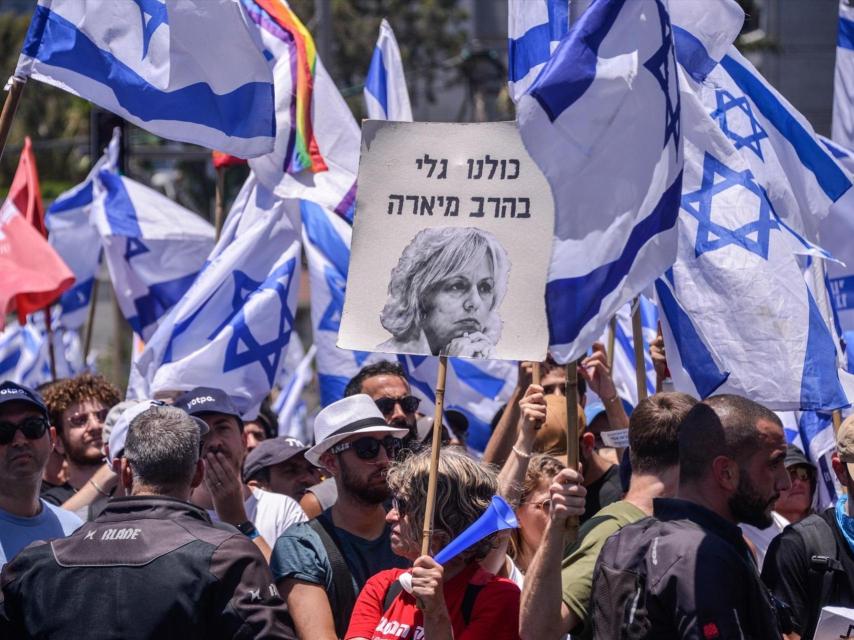 Los manifestantes tienen banderas israelíes y un póster que dice que todos somos Gali Baharav-Miara (Fiscal General de Israel) durante una manifestación contra la reforma judicial.