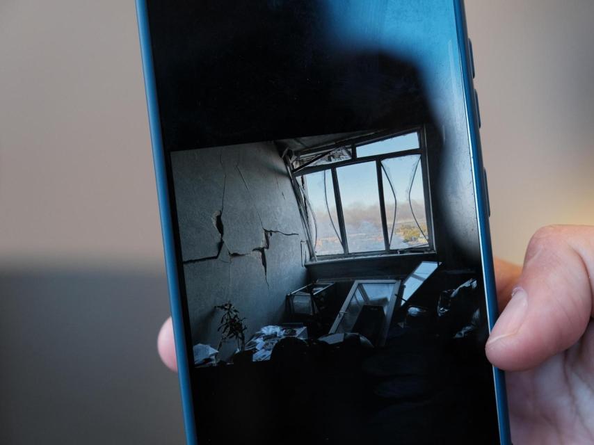 Olena muestra en la pantalla de su móvil una foto de cómo estaba su sala de estar después del bombardeo ruso que destruyó la última casa en la que había vivido.