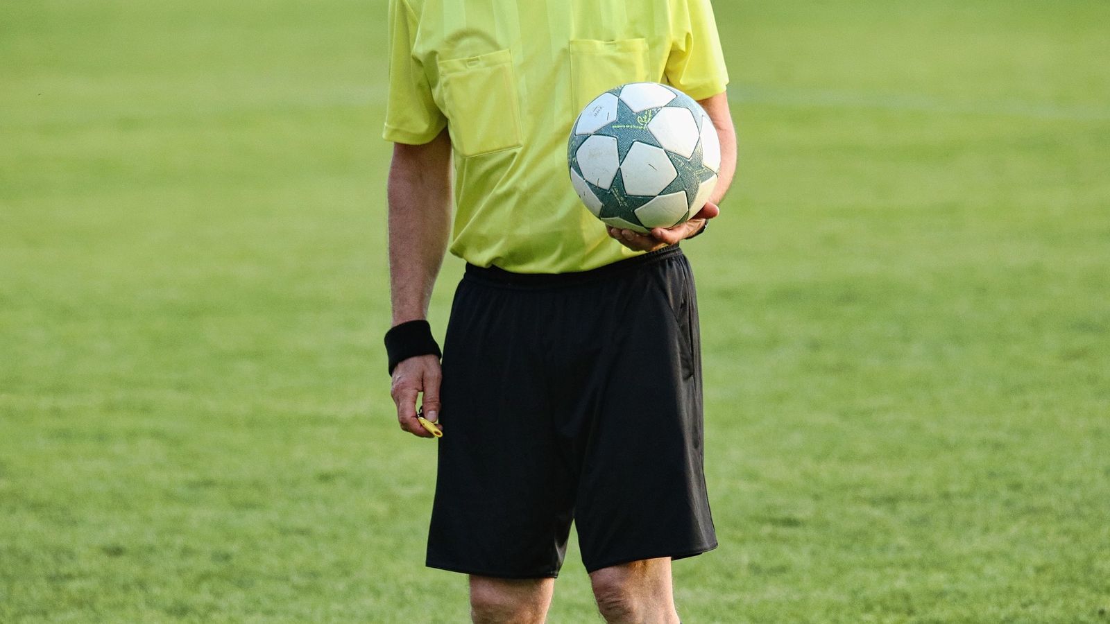 Árbitro sosteniendo fútbol