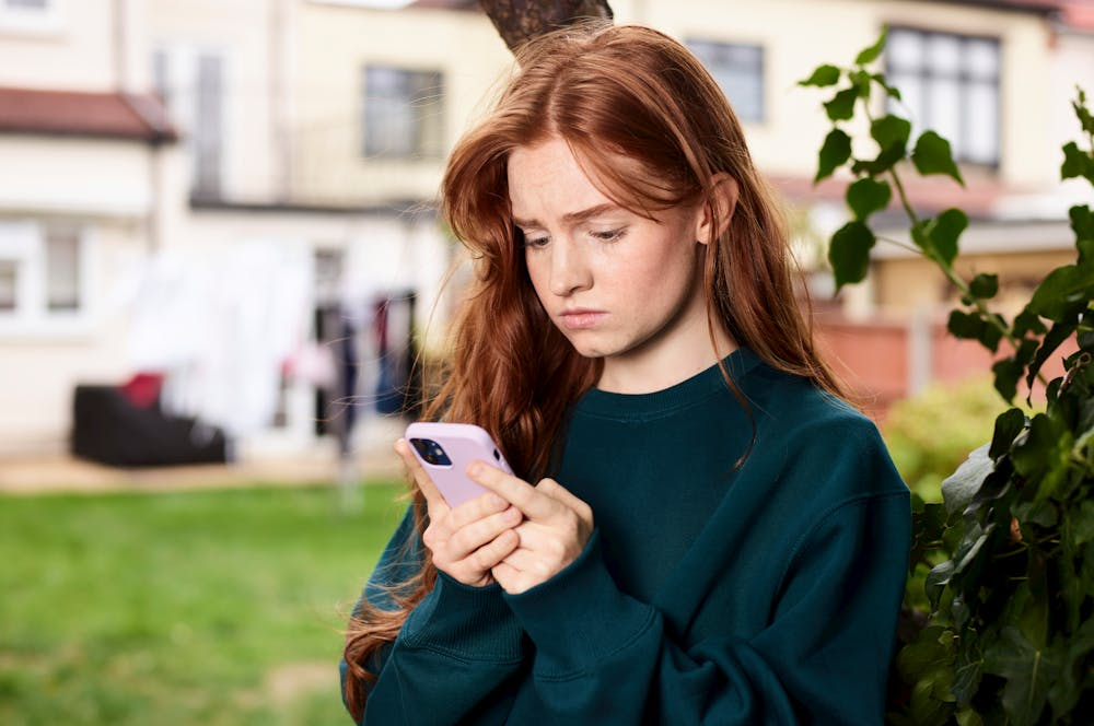 Mujer mirando el teléfono móvil preocupada
