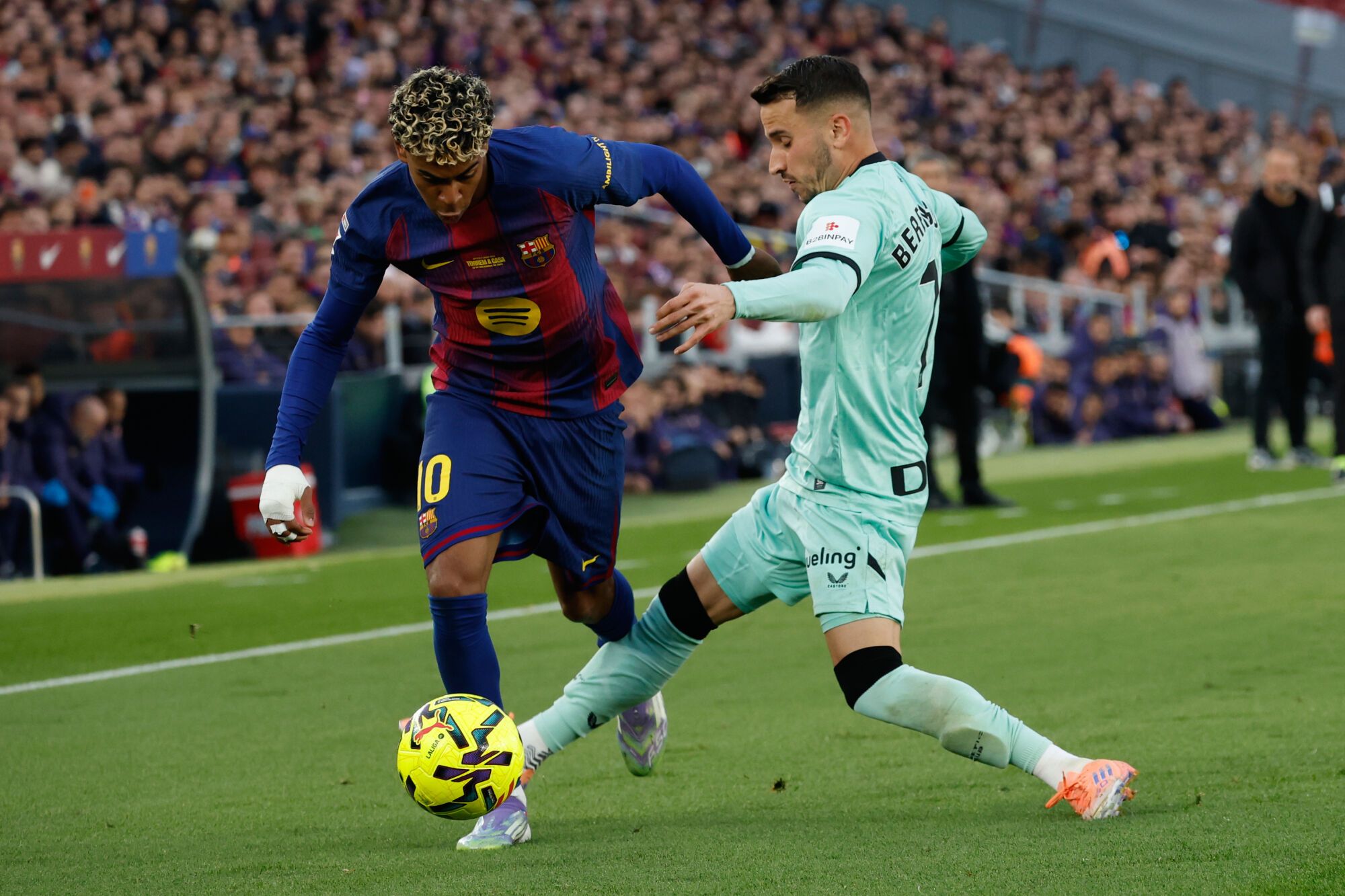 Lamine Yamal del Barcelona, ​​izquierda, y Alex Berenguer del Athletic de Bilbao pelean por el balón durante un partido de fútbol de La Liga entre Barcelona y Athletic en Barcelona, ​​España, el sábado 22 de noviembre de 2025. Foto AP/Joan Monfort)