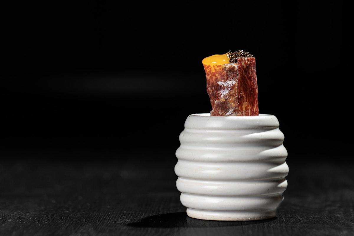 Croquet Gunkan. Croqueta de chipotle ahumado, harina de wagyu seca, yema de huevo deshidratada, tobiko negro.