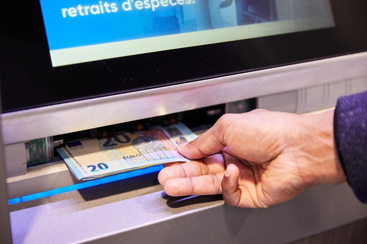 Una persona retira dinero de un cajero automático.