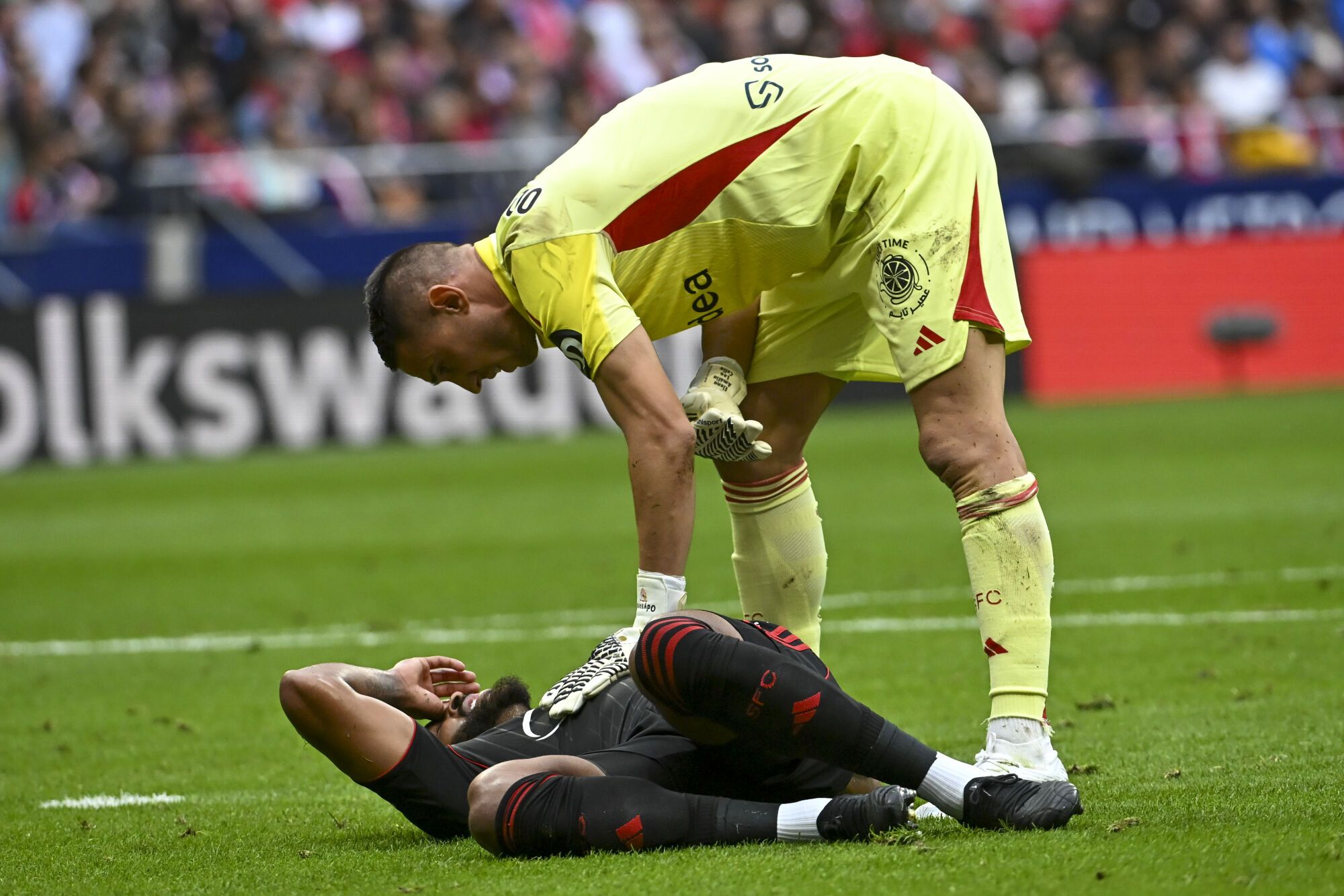 MADRID, 11/01/2025.- El portero griego del Sevilla Odysseas Vlachodimos con su compañero brasileño Marcao do Nascimento (en el terreno) durante un partido de la Liga entre el Atlético de Madrid y Sevilla, este sábado en el estadio Metropolitano. EFE/Fernando Villar. *****SÓLO PARA USO EDITORIAL/SÓLO DISPONIBLE PARA ILUSTRAR LAS NOTICIAS QUE LO ACOMPAÑAN (CRÉDITO OBLIGATORIO) *****