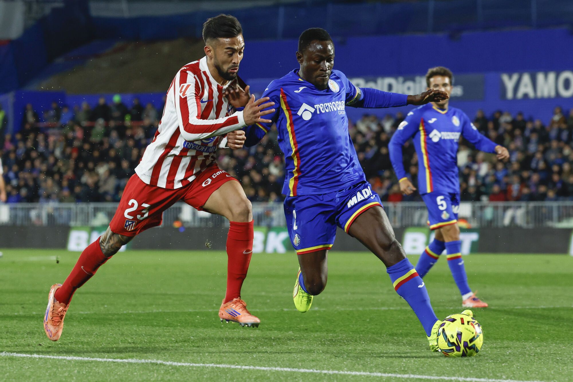 GETAFE (MADRID), 23/11/202.- El centrocampista argentino del Atlético de Madrid Nicolás González (i) pelea con Djené Dakonam, del Getafe, durante el partido de la jornada 13 de LaLiga que disputan este domingo Getafe CF y Atlético de Madrid en el Coliseum de Getafe. EFE/JJ Guillén
