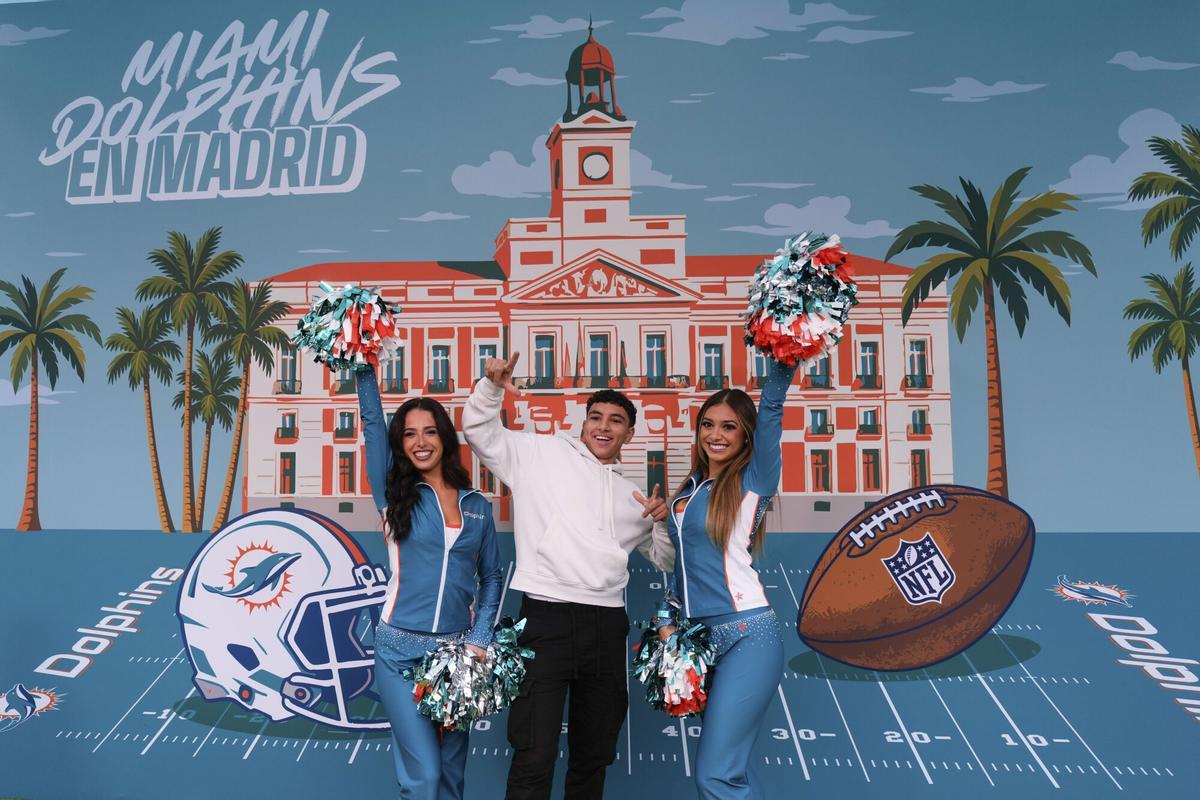 Varias personas se divierten en la zona de fans de los Miami Dolphin en la Plaza de España de Madrid.