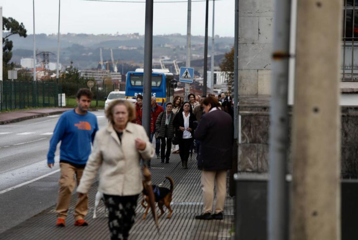 Fieles, al mediodía, en el cementerio avilesino, durante la misa.