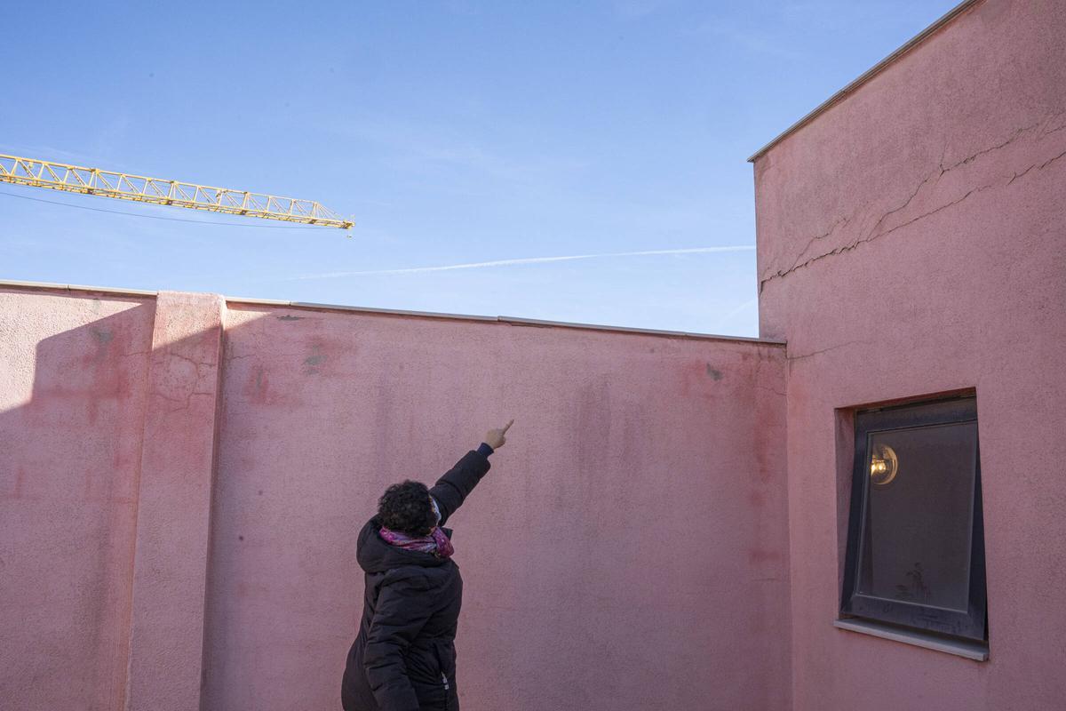 Un vecino señala unas grietas en la terraza de la comunidad que ha demandado a Limañ y al Barça por los daños supuestamente causados por la construcción del Camp Nou, en Barcelona.