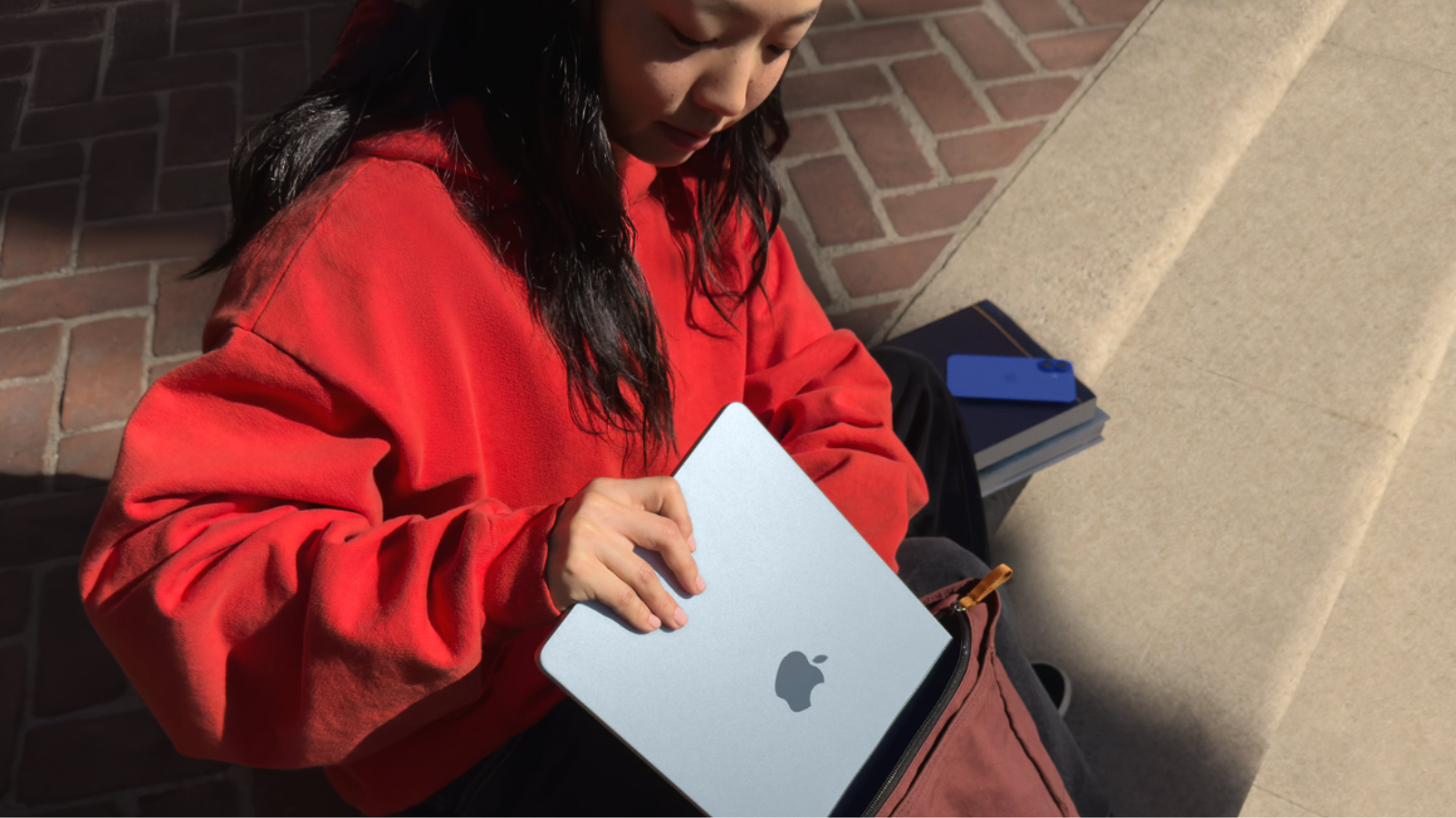 Una niña mete el Apple MacBook Air M4 en su mochila