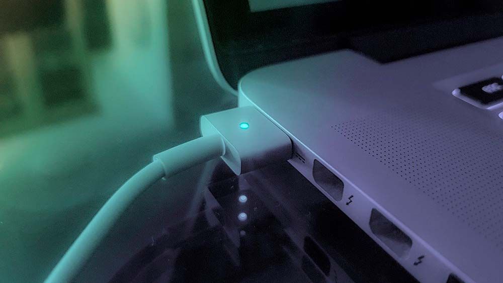 Cargador de computadora portátil conectado a una fuente de energía, lo que ilustra la importancia de administrar el tiempo de carga