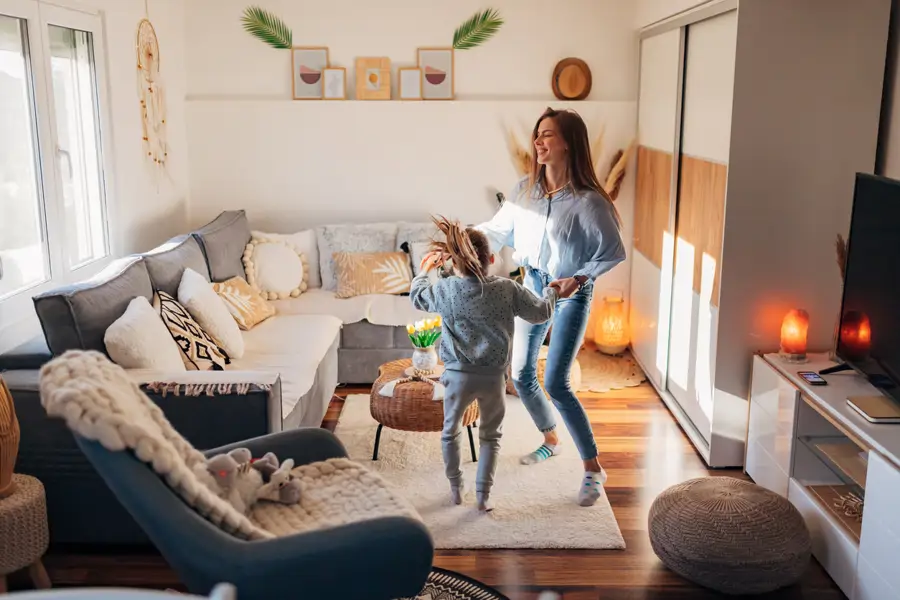Madre e hija bailando en el comedor de casa