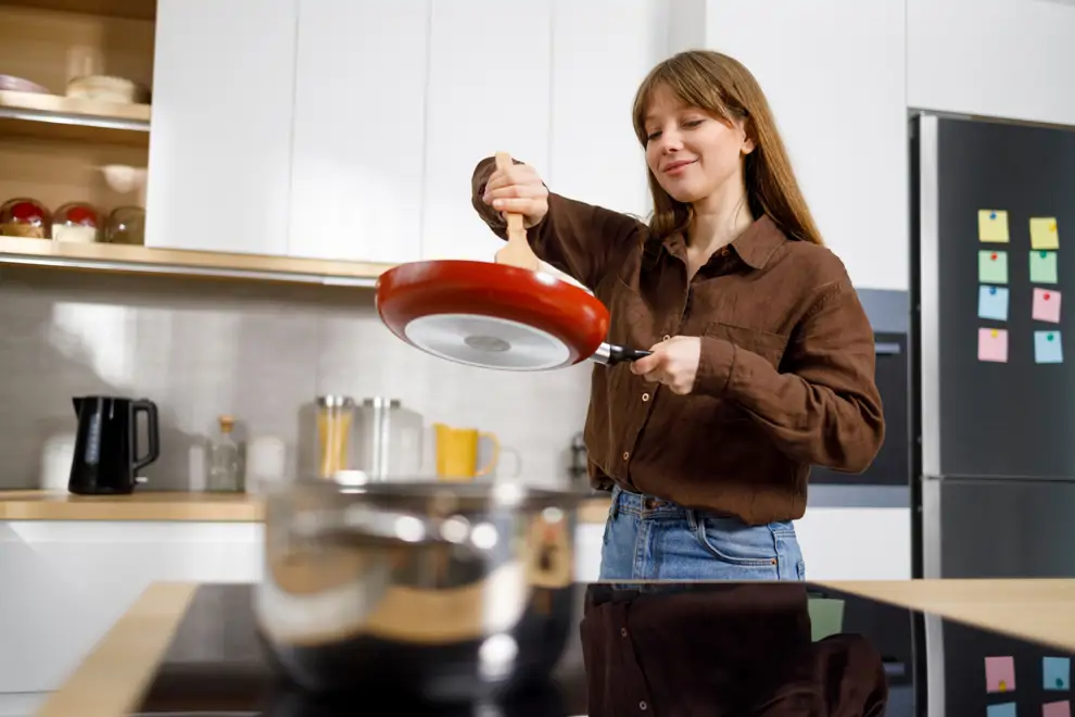 Mujer cocinando con una sartén