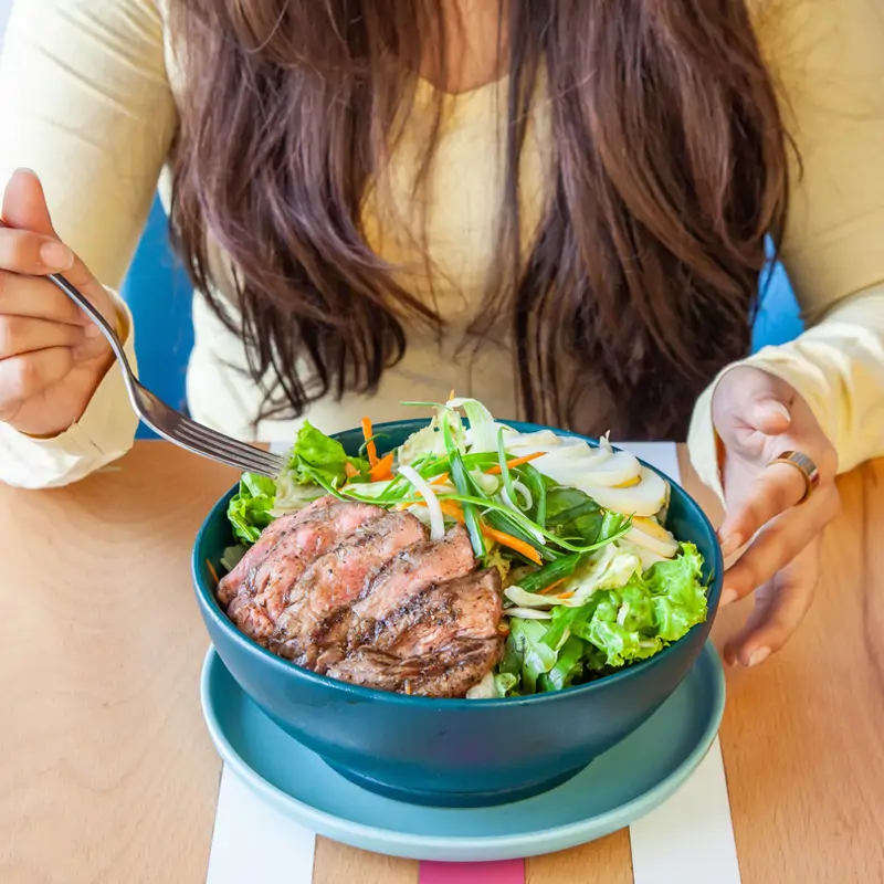 Mujer comiendo carne roja 