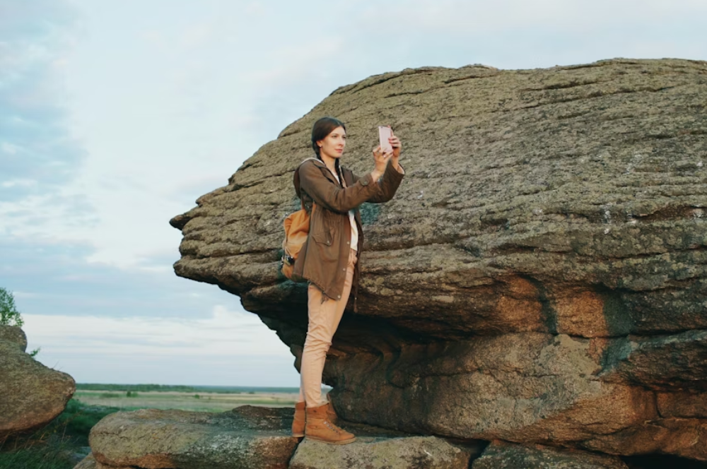 Mujer sosteniendo un teléfono móvil en una zona remota