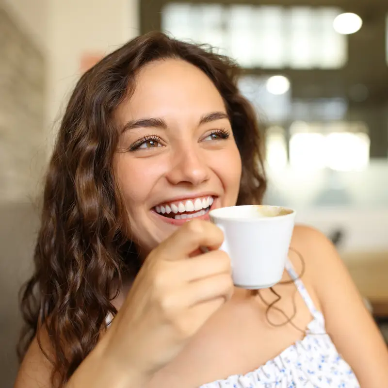 MUJER JOVEN TOMANDO CAFÉ