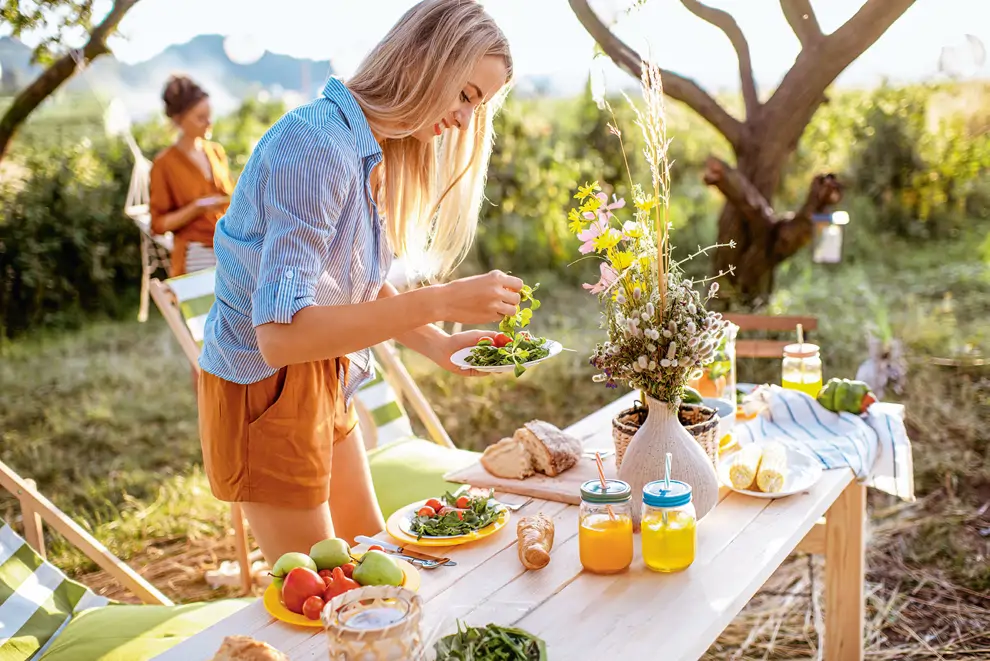 La mujer prepara ensalada y comida sana.
