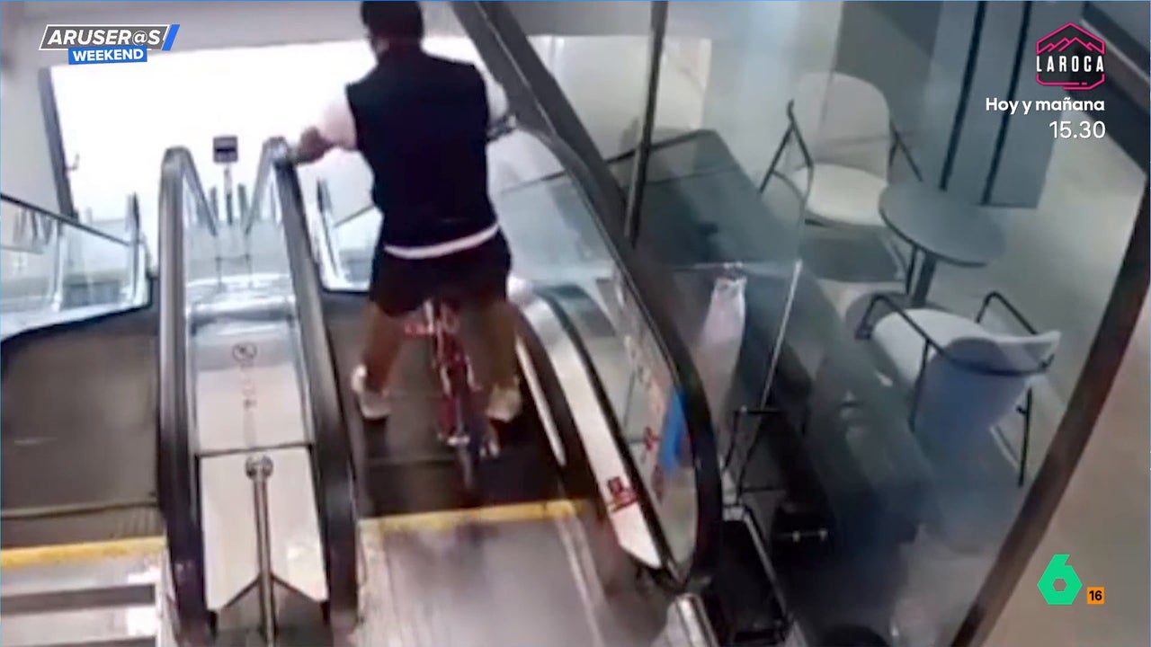 El vídeo del hombre que intenta bajar unas escaleras mecánicas subido en su bici… y esto es lo que le pasa