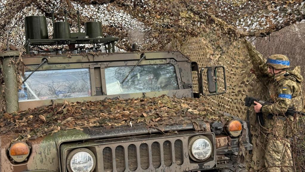 Un soldado ucraniano esconde un Humvee en las afueras de Kupiansk.