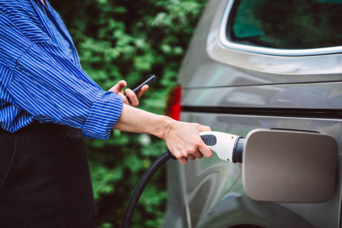Mujer cargando su coche eléctrico