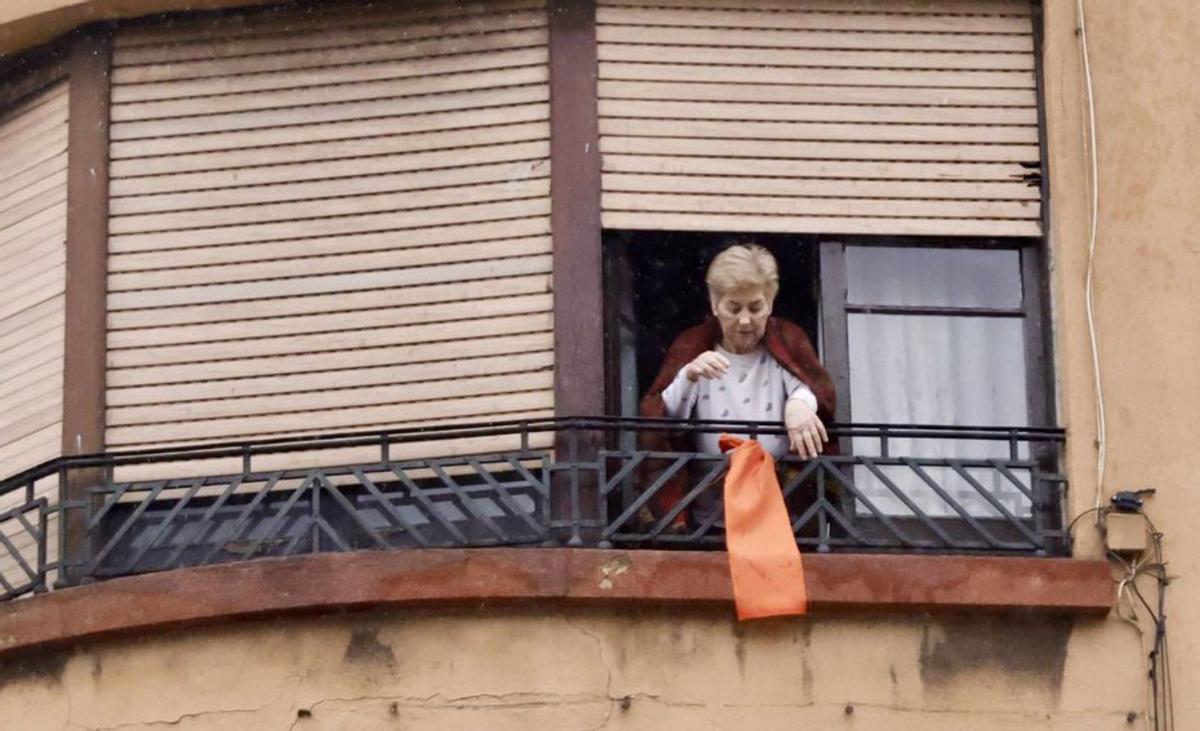 Azucena Díaz, colocando un trapo naranja en señal de protesta.