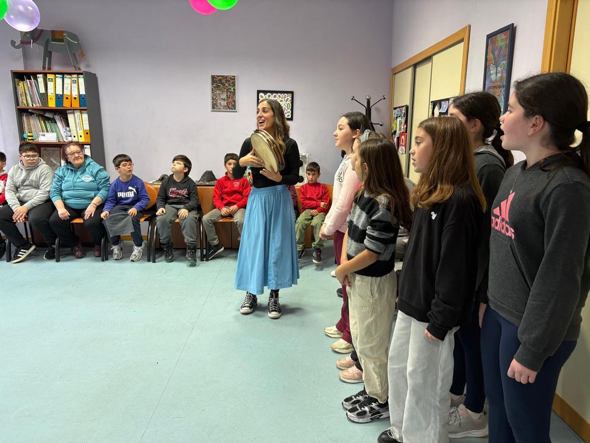 Sandra Flórez, al pandero, y un grupo de alumnos cantan un son d'arriba.