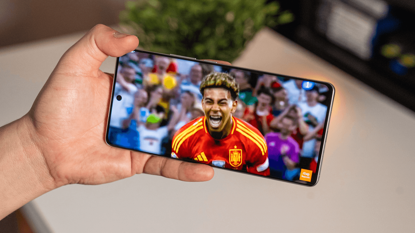 Partido de fútbol transmitido en vivo en un teléfono inteligente Android a través de una aplicación de transmisión, césped verde y jugadores en movimiento, con Lamine Yamal