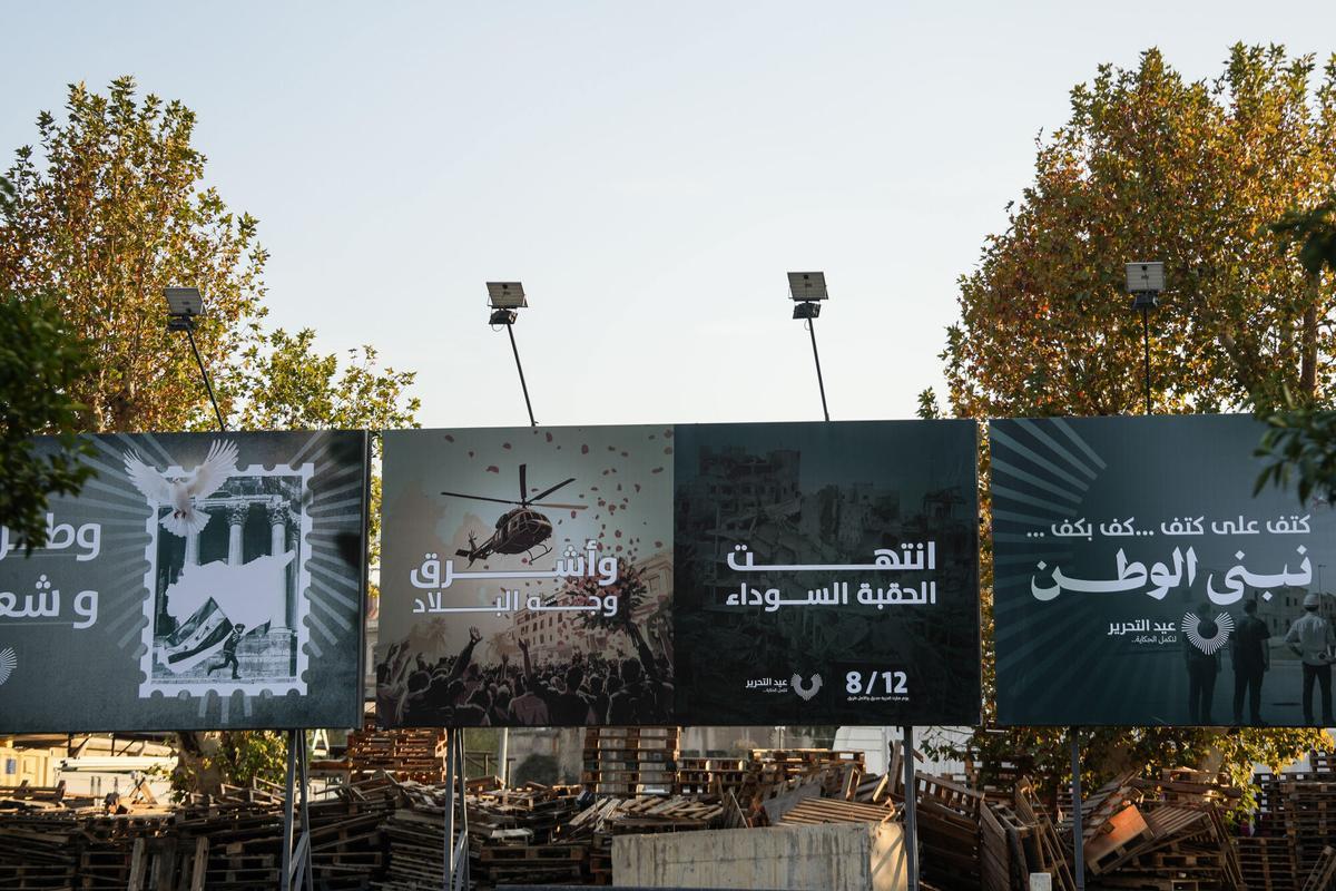 Carteles que decían 'La era negra ha terminado y el rostro del país ha comenzado a brillar'"en Damasco, con motivo del primer aniversario de la caída del régimen de Assad.