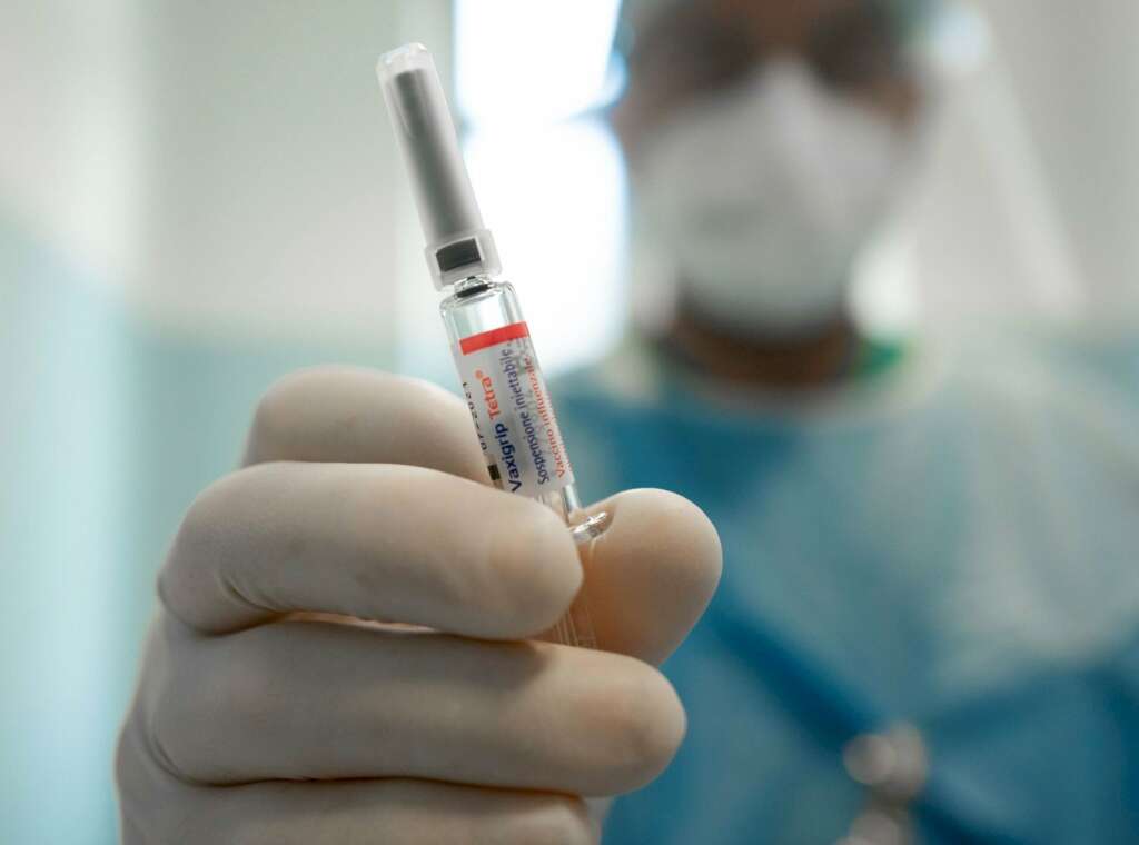 Un médico en Milán (Italia) sostiene una vacuna contra la gripe / EFE