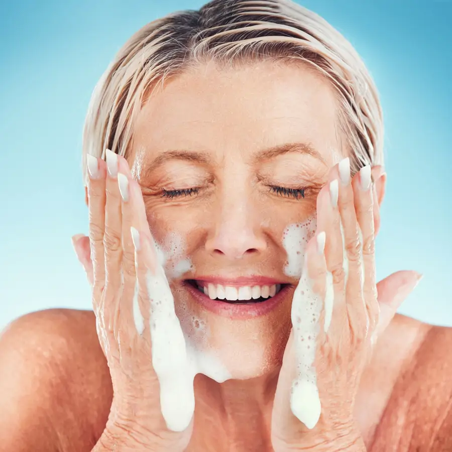 Mujer madura lavándose la cara