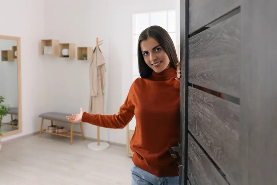 Mujer abriendo la puerta de su casa a los invitados
