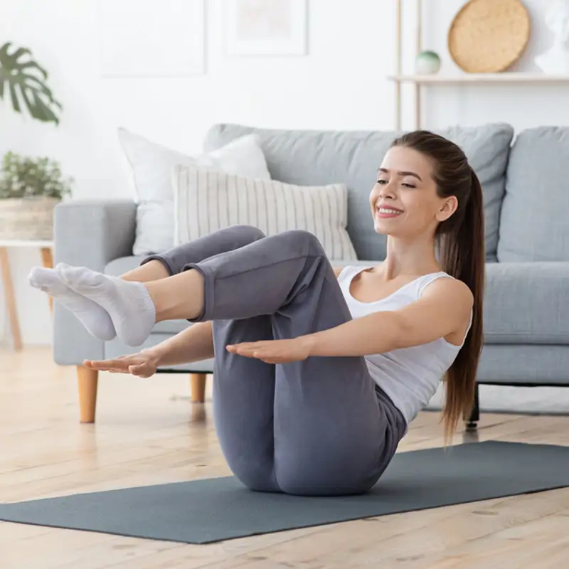 Una mujer realiza la posición de Pilates llamada cien