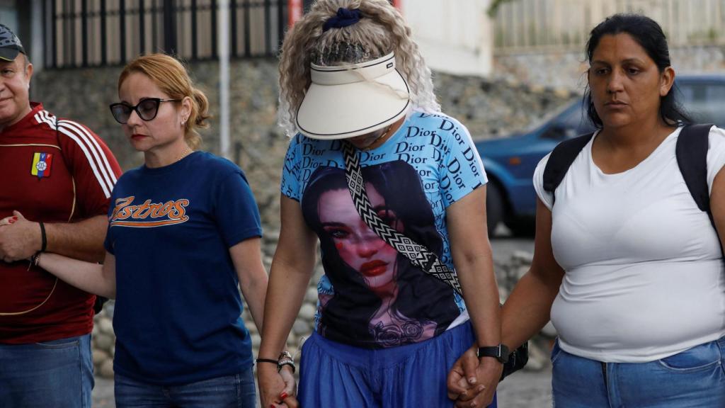 Familiares y activistas de derechos humanos rezan mientras protestan frente a la sede del Helicoide para exigir la liberación de los presos políticos.