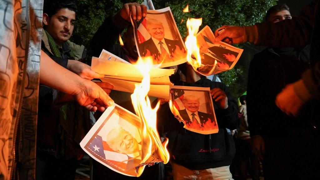 Simpatizantes de grupos armados chiítas iraquíes queman imágenes del presidente estadounidense, Donald Trump, y del primer ministro israelí, Benjamín Netanyahu, durante una manifestación de solidaridad con el Gobierno de Irán en Teherán, frente al consulado iraní en Basora.