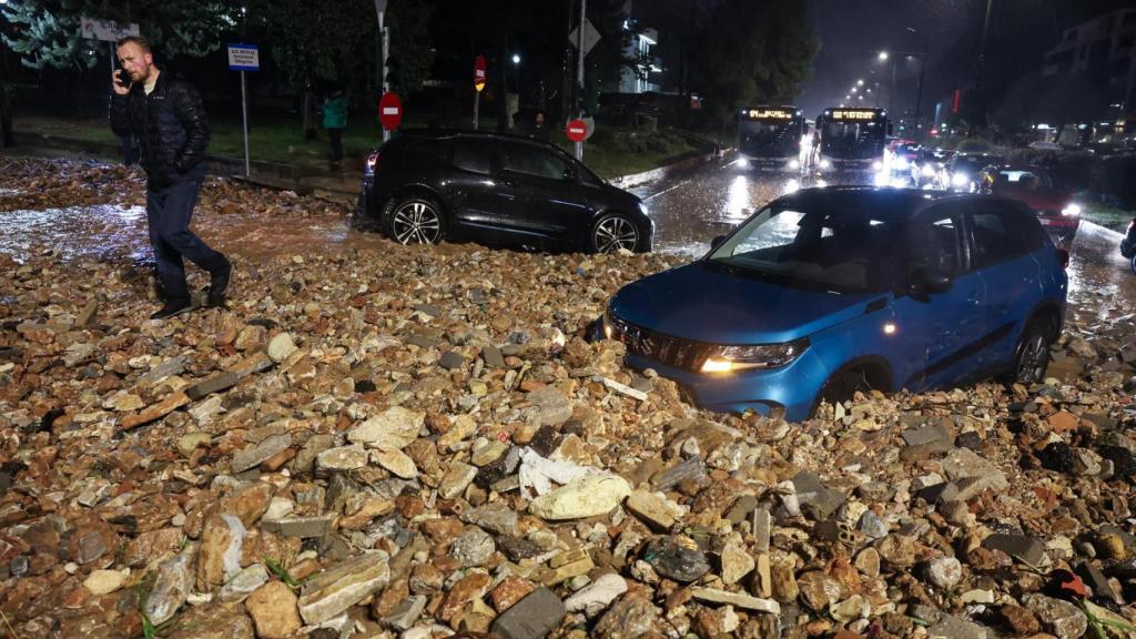 Una persona camina por un sendero cubierto de rocas y barro durante una tormenta en Voula, cerca de Atenas, Grecia, el 21 de enero de 2026.