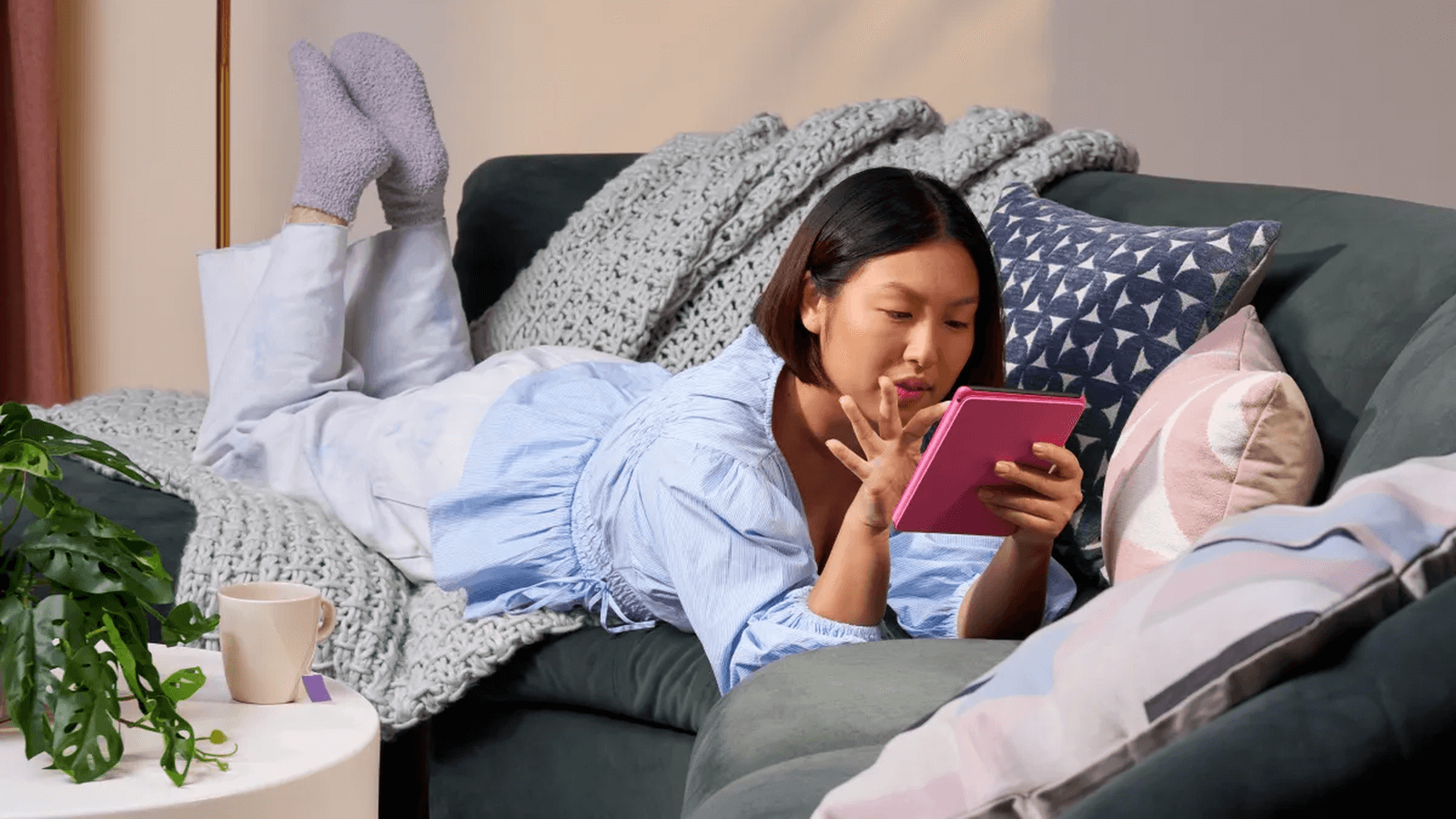 Una mujer yace leyendo en su Kindle