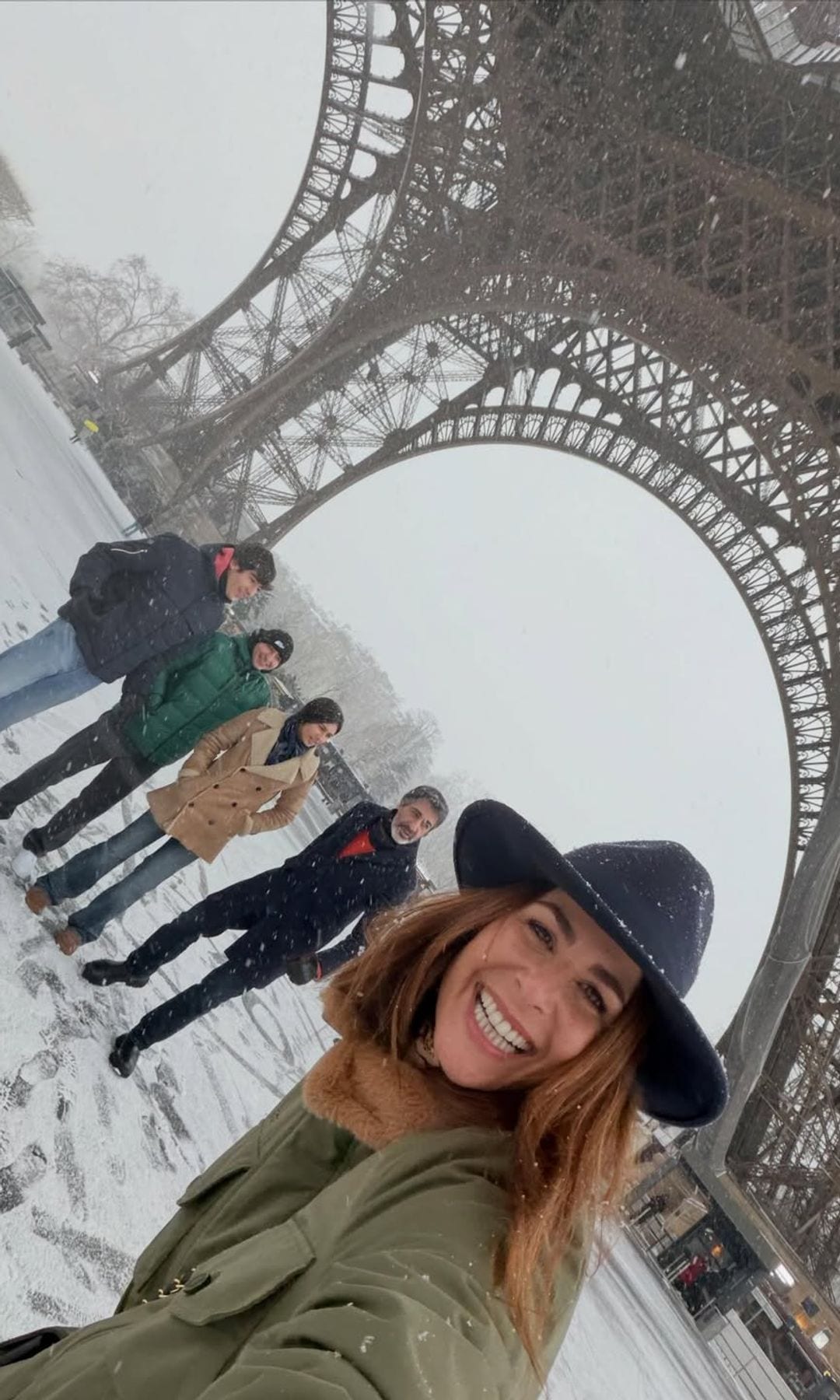 Nuria Roca y su familia bajo la Torre Eiffel en París en un día de nieve, Francia