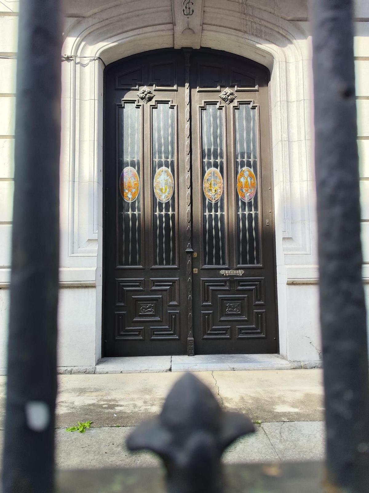 Detalle de la puerta, con las iniciales del propietario en el cristal.