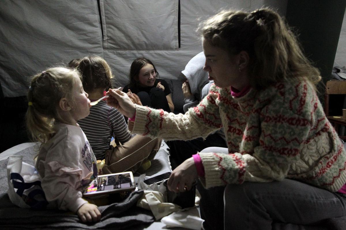Una niña alimenta a otra niña en una de las tiendas de campaña instaladas en el distrito Desnianskyi de Kiev.