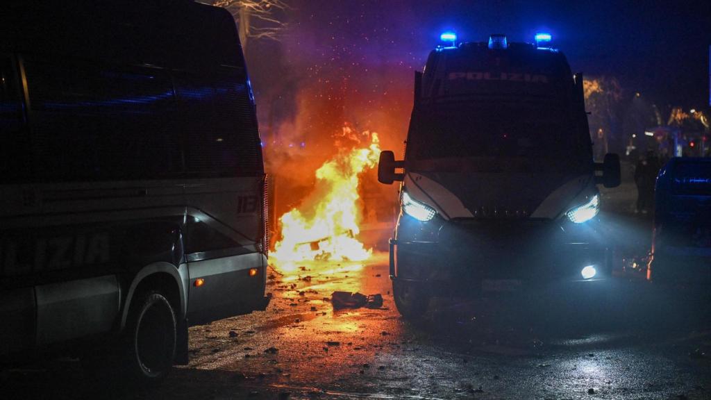 Vehículos policiales blindados durante enfrentamientos con manifestantes tras una marcha en apoyo de Askatasuna en Turín.