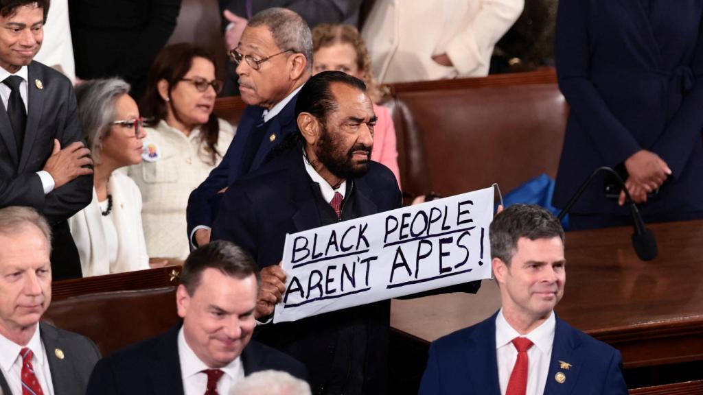 Al Green, un congresista de Texas, sostiene un cartel que dice