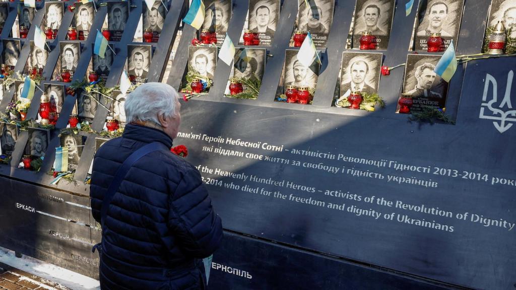 Una persona conmemora un monumento a las víctimas caídas en los conflictos bélicos en Kiev.