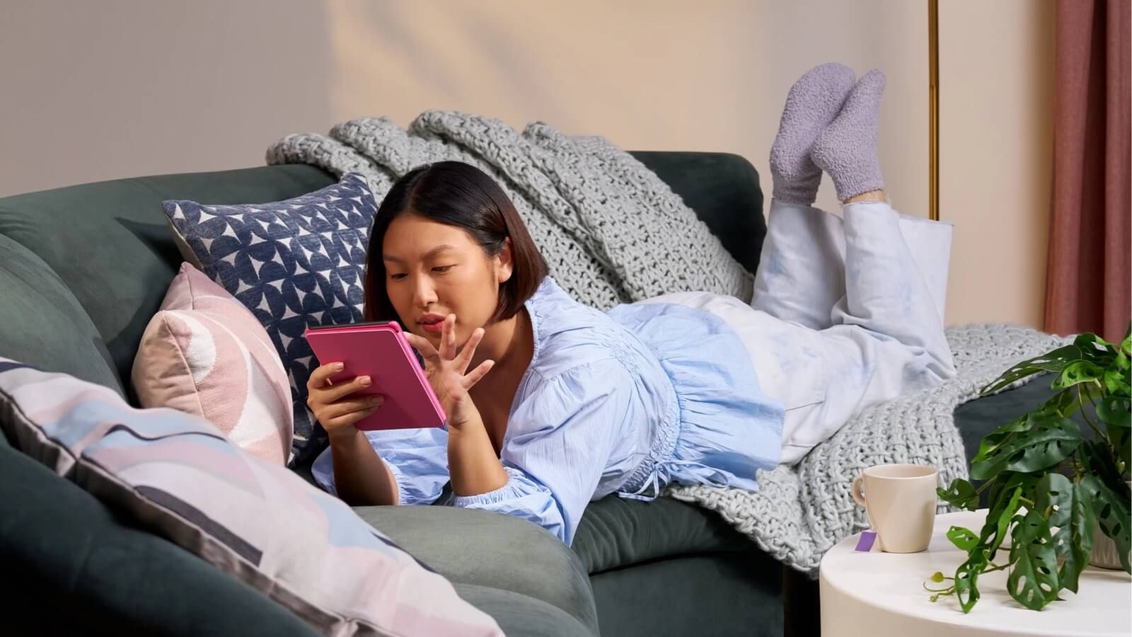 Una niña yace leyendo un libro en un Kindle
