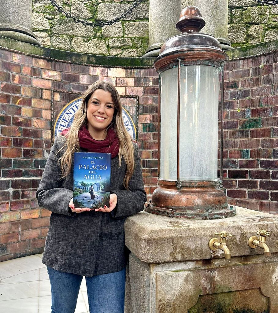 Laura Portas pose dans l'emblématique fontaine A Gándara du Balneario de Mondariz avec son nouveau livre 'Le Palais de l'Eau'.