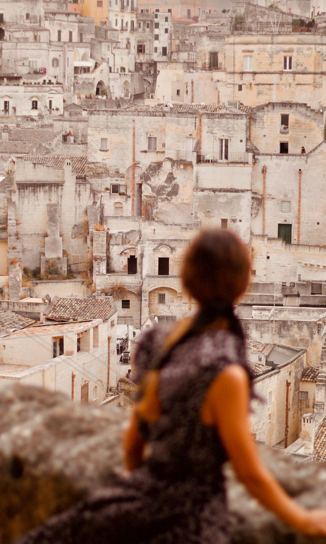 Mujer mirando desde uno de los miradores de la ciudad de Matera, Italia